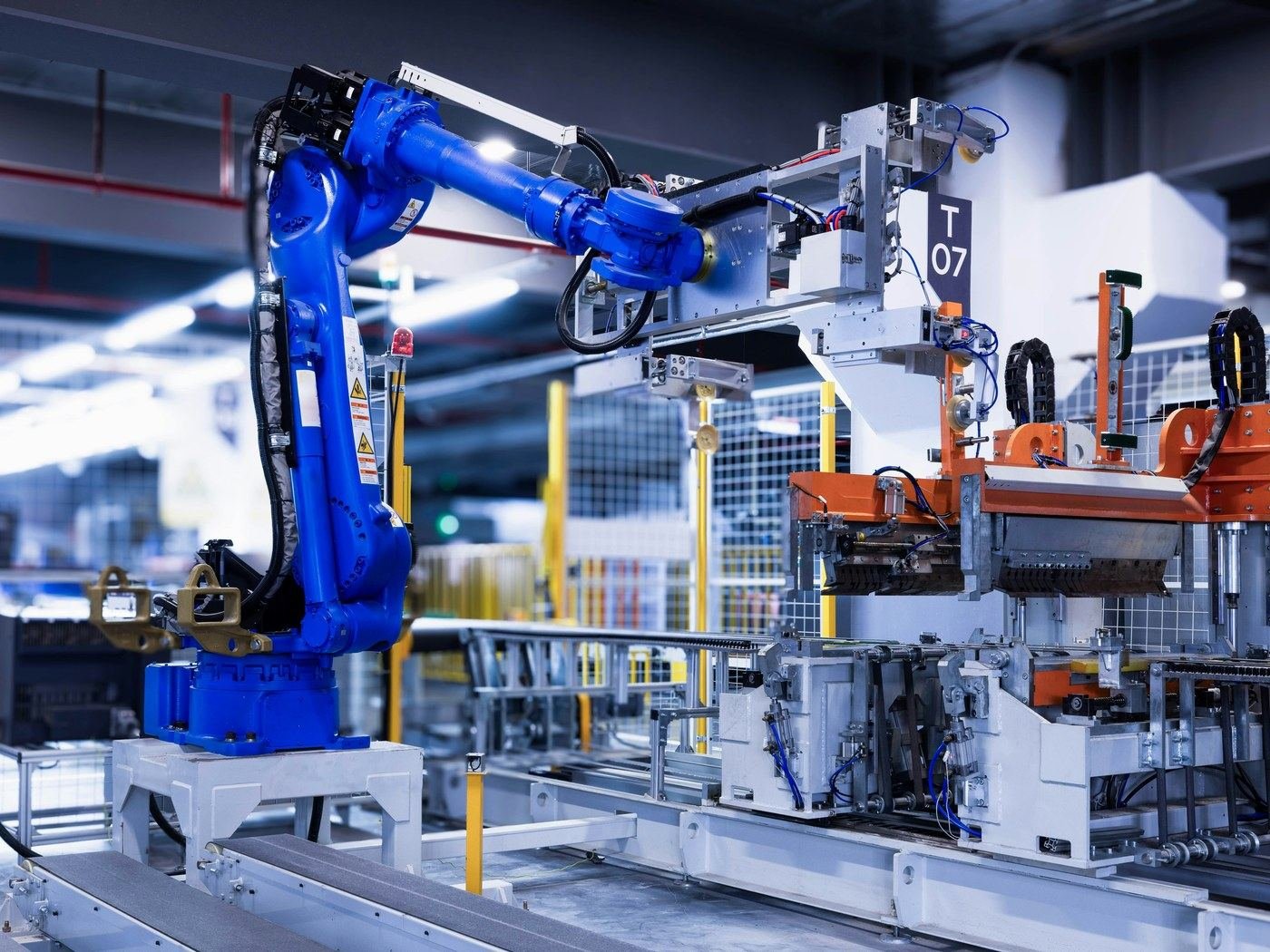 Braccio robotico blu integrato in una linea di produzione